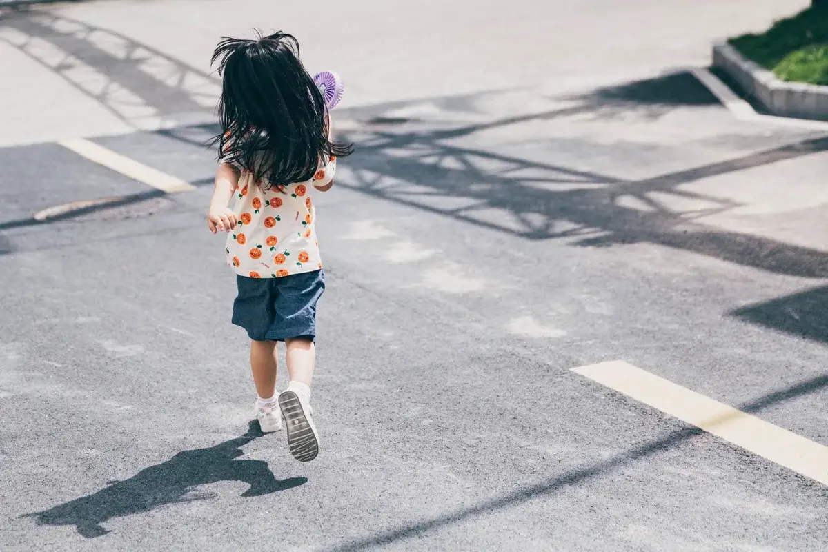 Young girl running on sunlit street