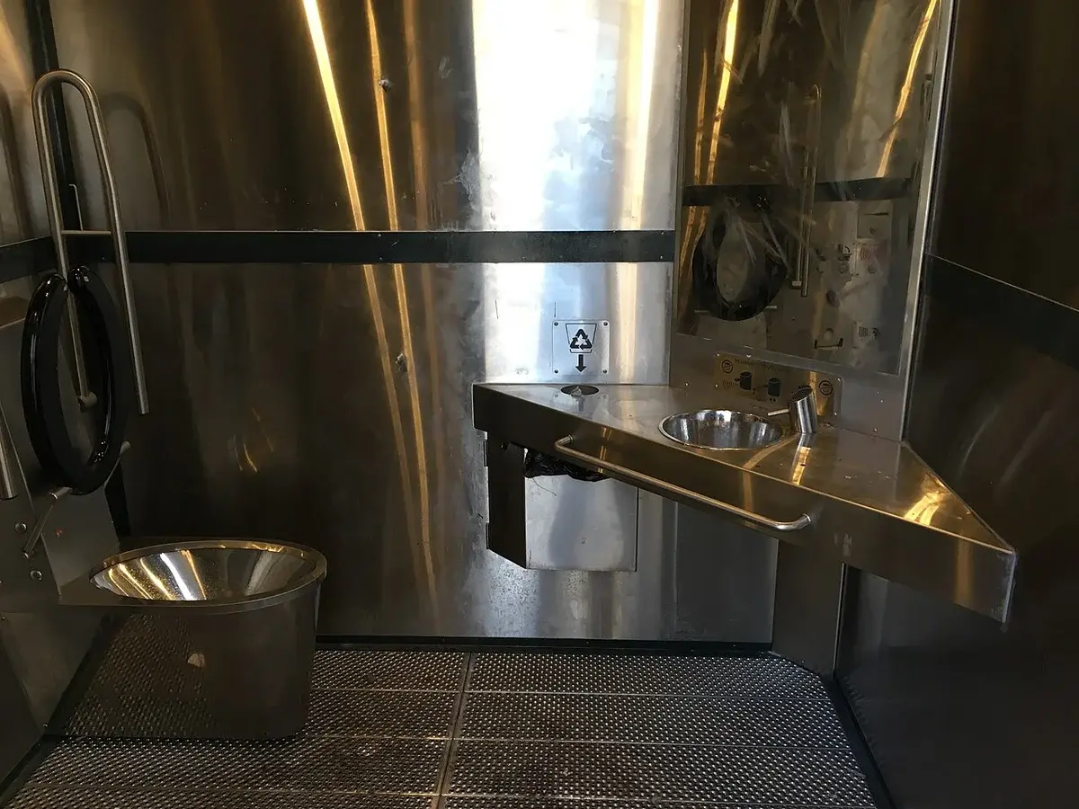 Interior of modern stainless steel gender-neutral public toilet