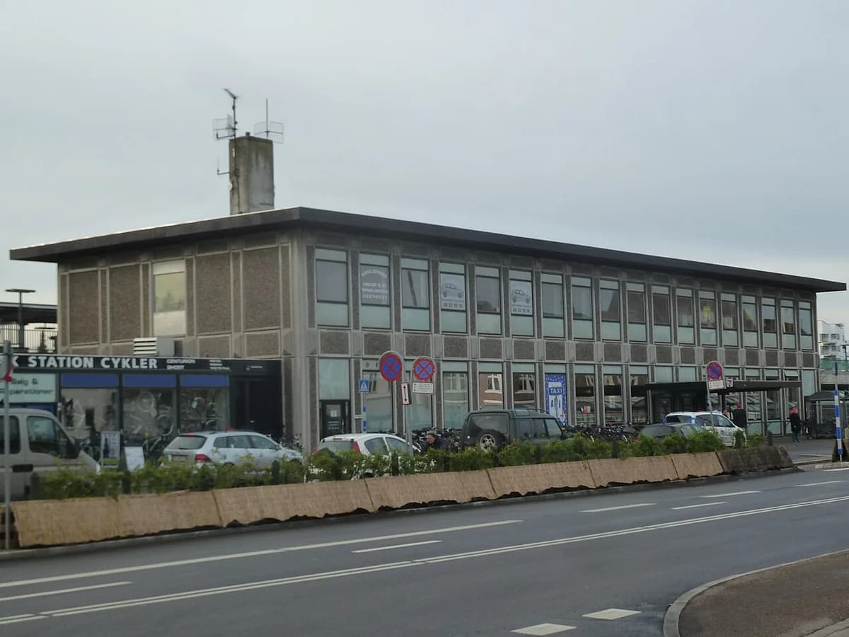 Modern building of Holbæk Station with parked cars in front