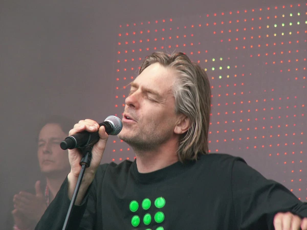 Peter A.G. Nielsen singing on stage into a microphone.