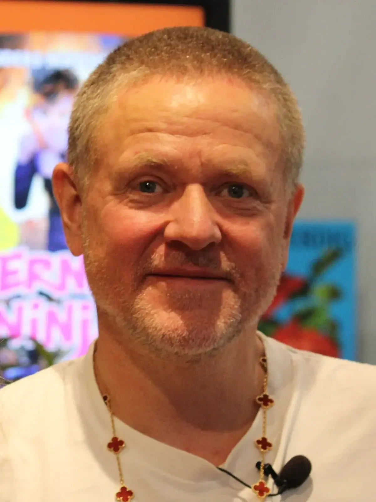 Close-up of a man with microphone and necklace
