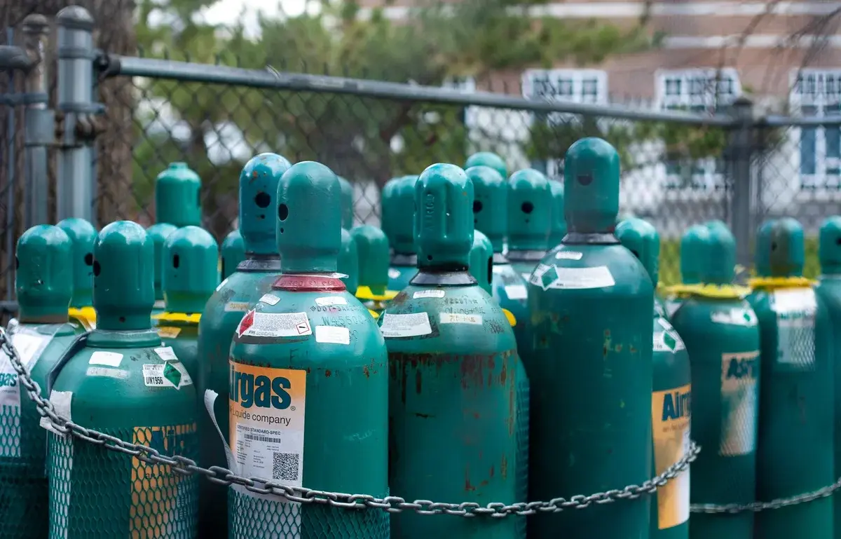 Teal gas cylinders chained together outdoors