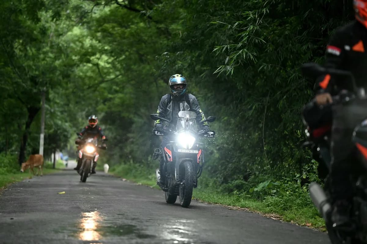 Motorcyclists riding on a forest road.