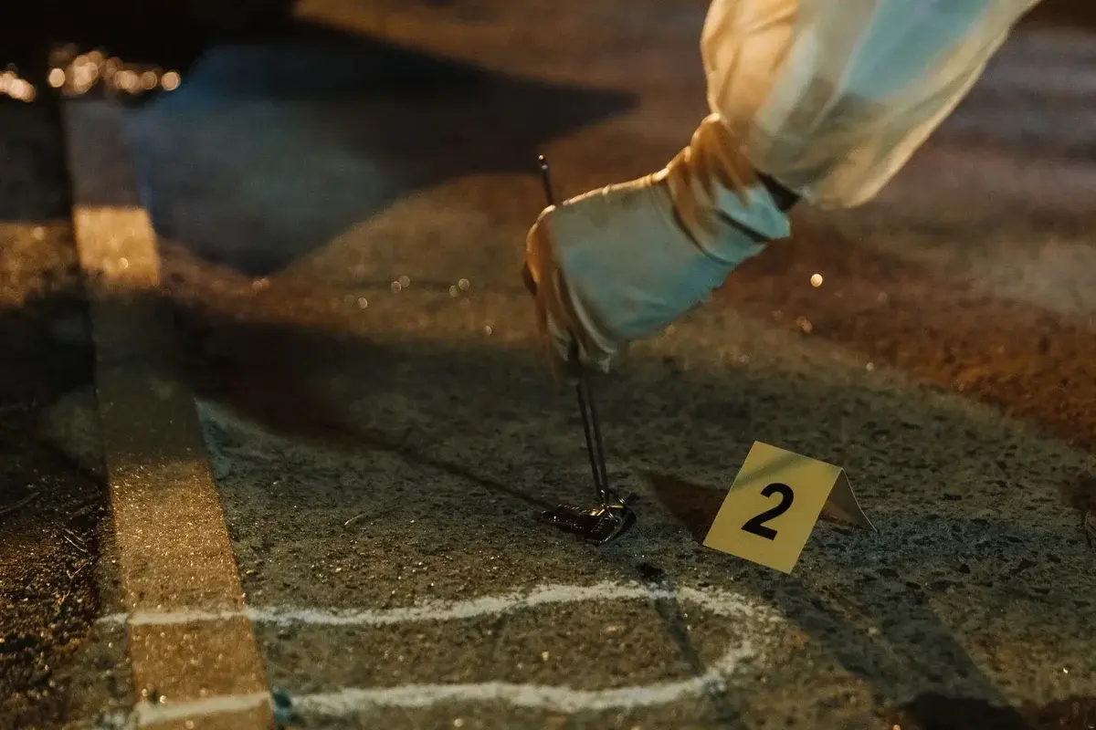 Forensic investigator collecting evidence with gloves at night crime scene