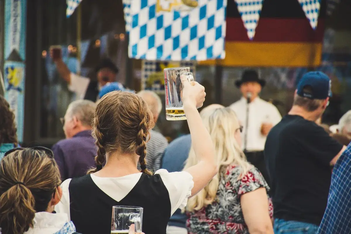 People enjoying Oktoberfest with raised beer mugs outdoors