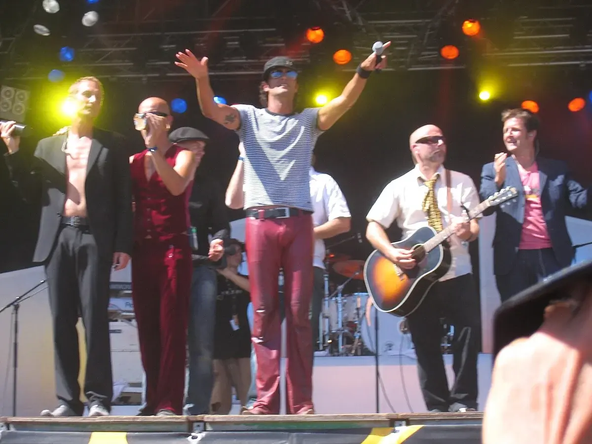 Band performing live on stage with bright lights