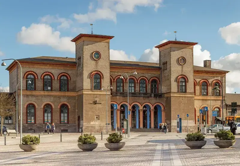 Roskilde Station building with people and taxis in front