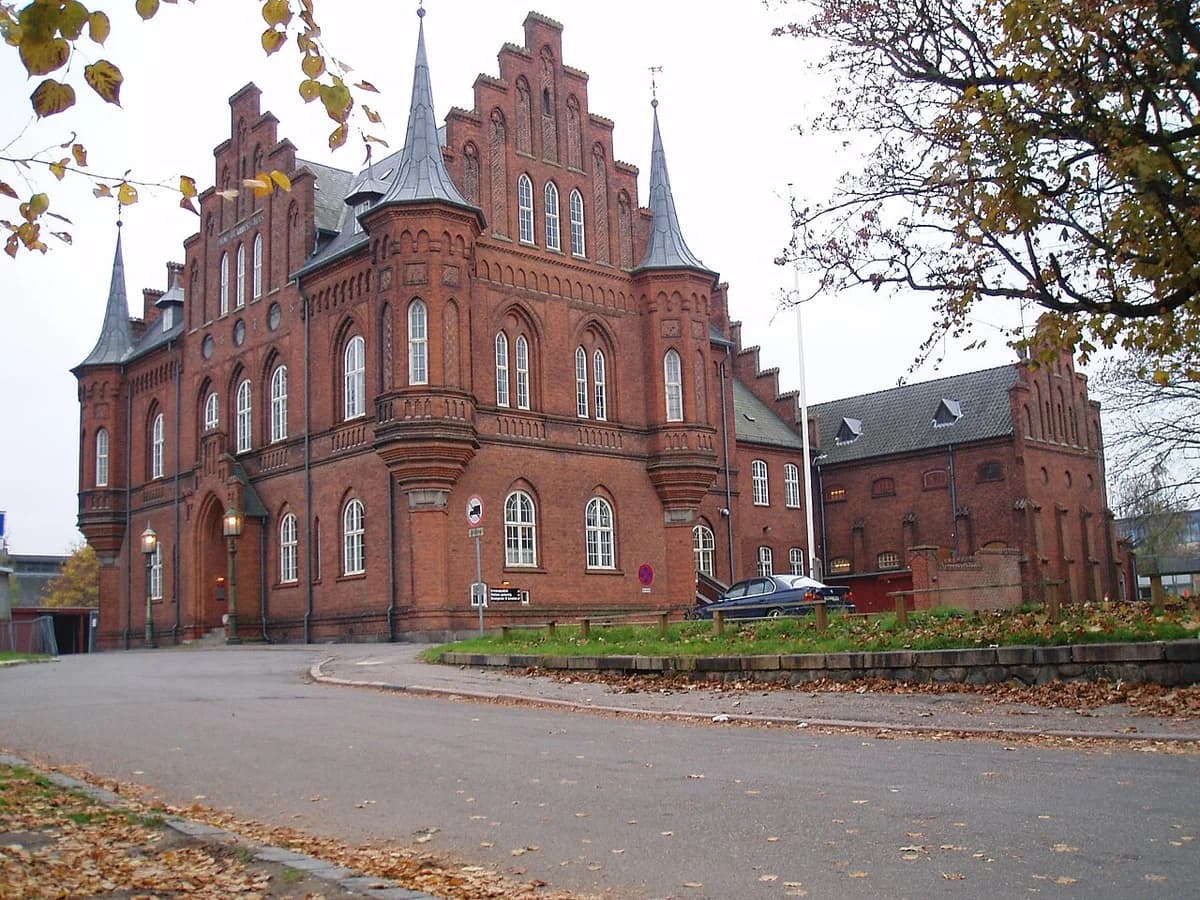 Historic red brick courthouse and jail building with pointed towers and arched windows
