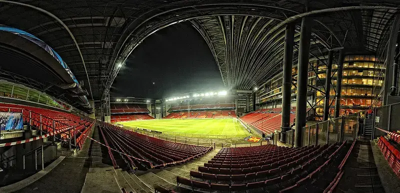 Nighttime view of empty football stadium with bright lights