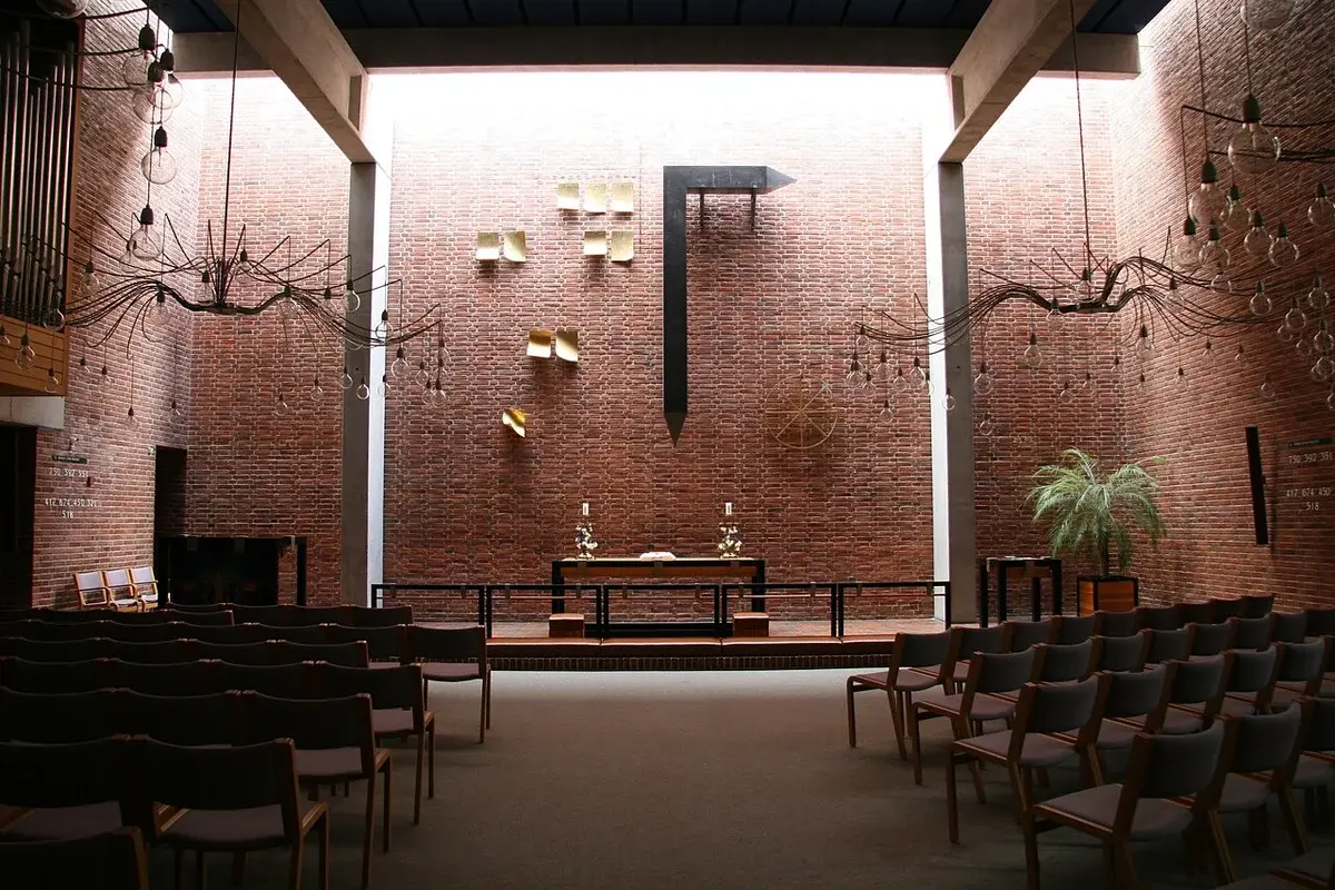 Interior of a modern brick church with chairs and an altar.