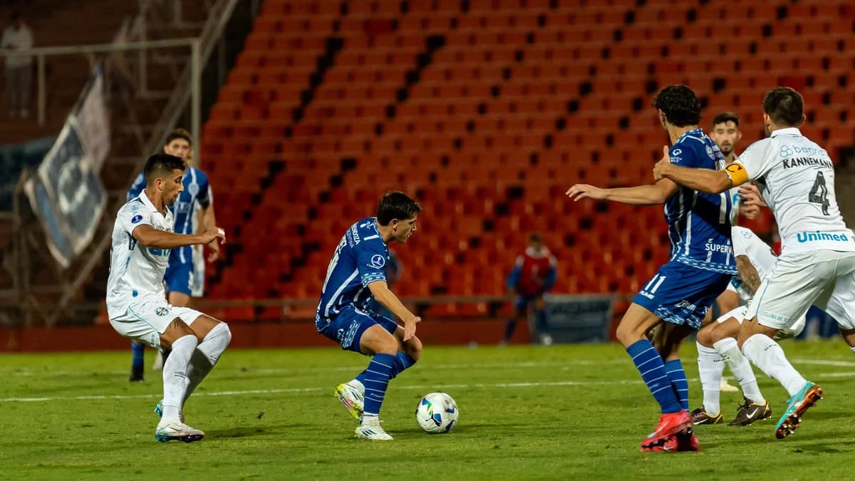 Soccer players contest the ball during a night match.
